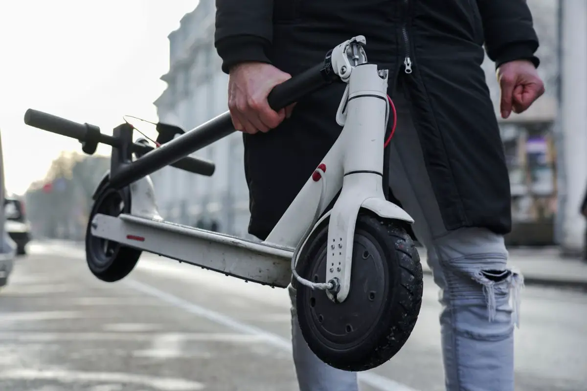 man holding foldable electric scooter